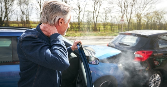 man holding his neck following a car accident
