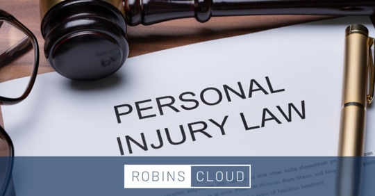 Piece of paper with "Personal Injury Law" printed on it. A gavel and a pen are resting on the paper.